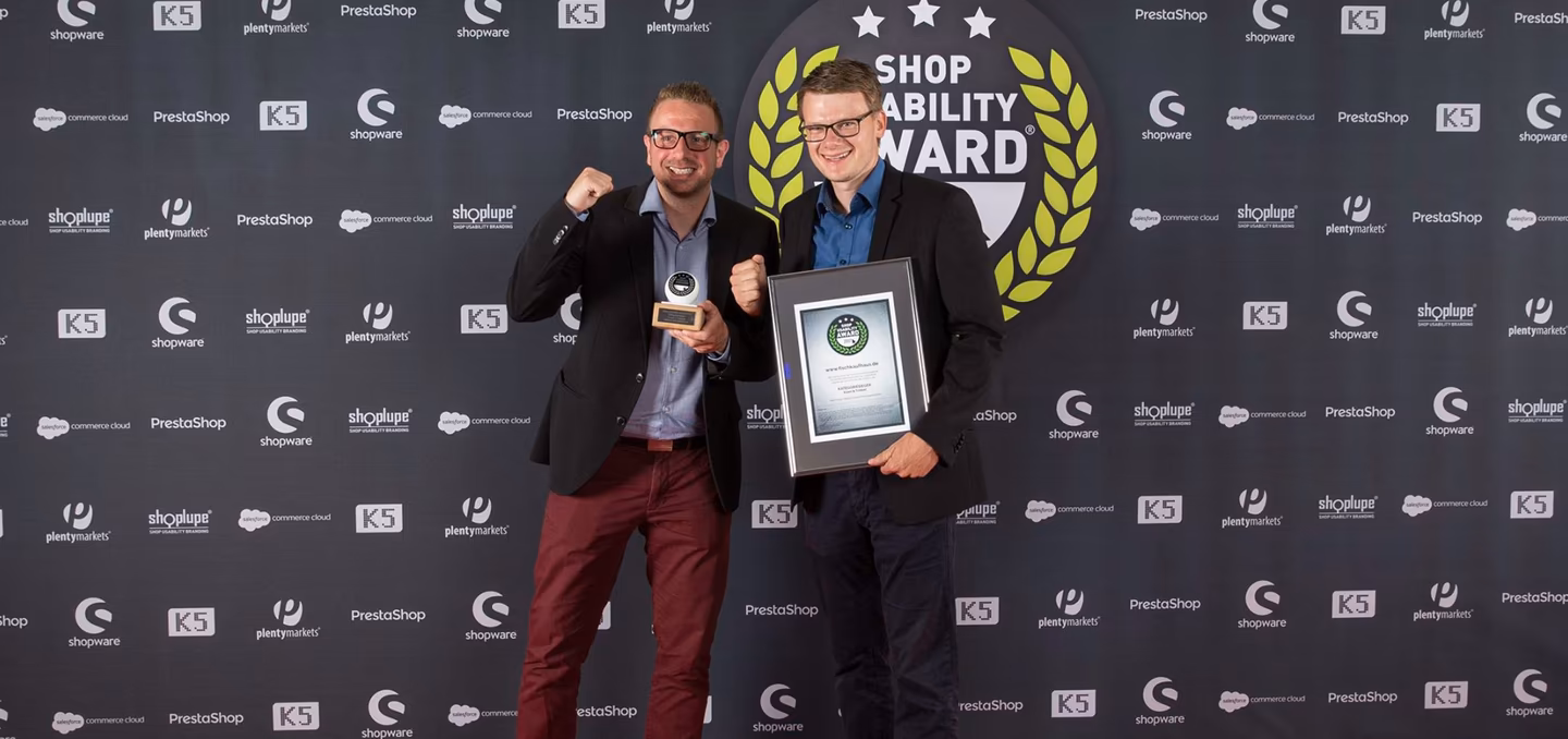 Zwei Vertreter von 4eck Media mit Shop Usability Award 2017 vor Fotowand