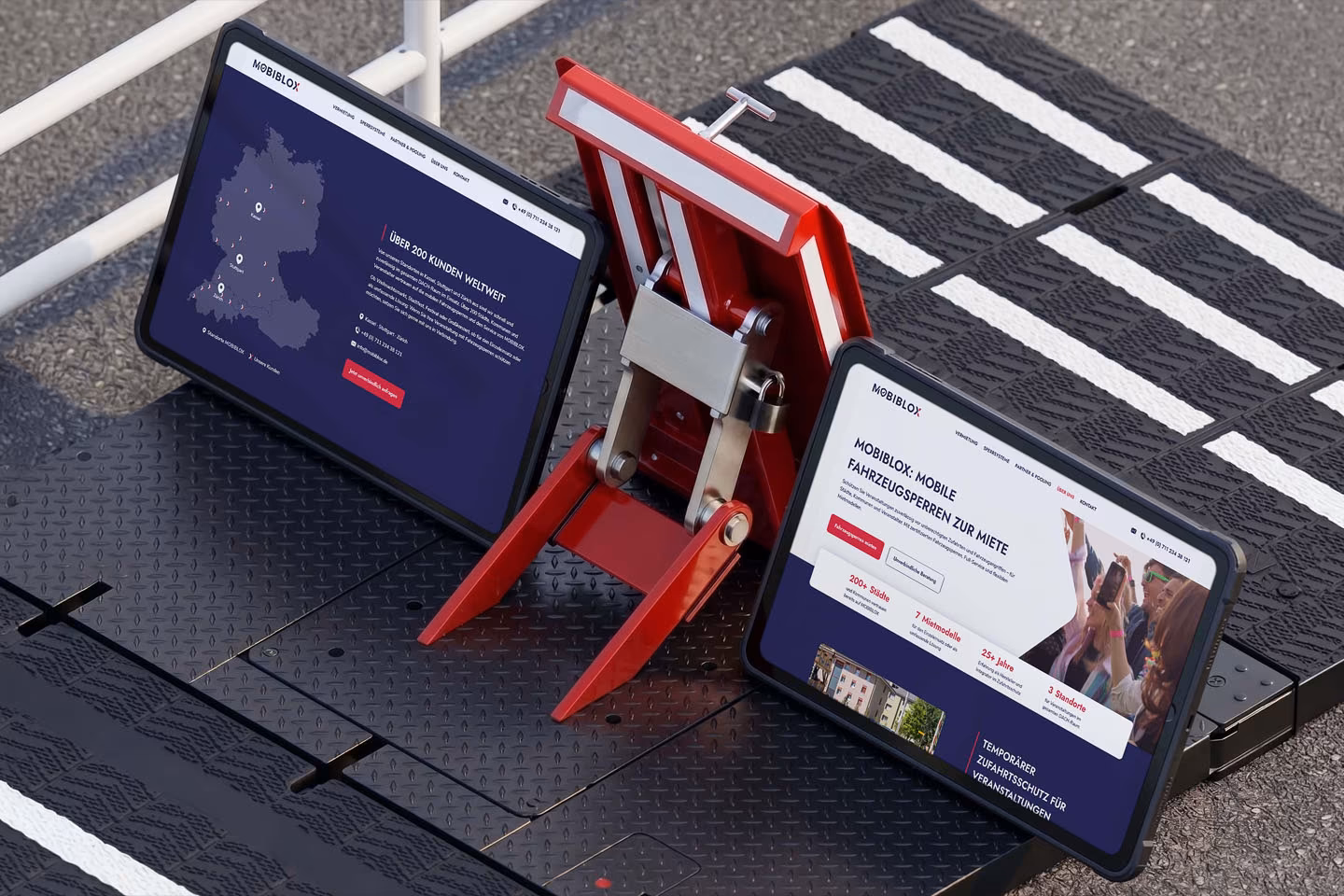 Zwei Tablets zeigen die neue Mobiblox Website neben einer roten mobilen Fahrzeugsperre zum tempor&auml;ren Zufahrtsschutz